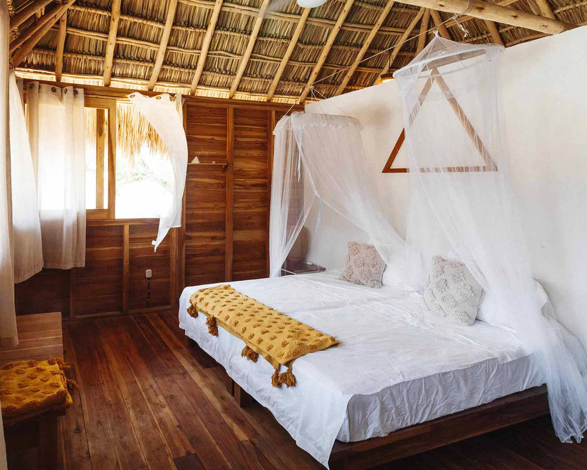 Chambre privée avec lit à baldaquin au surf lodge