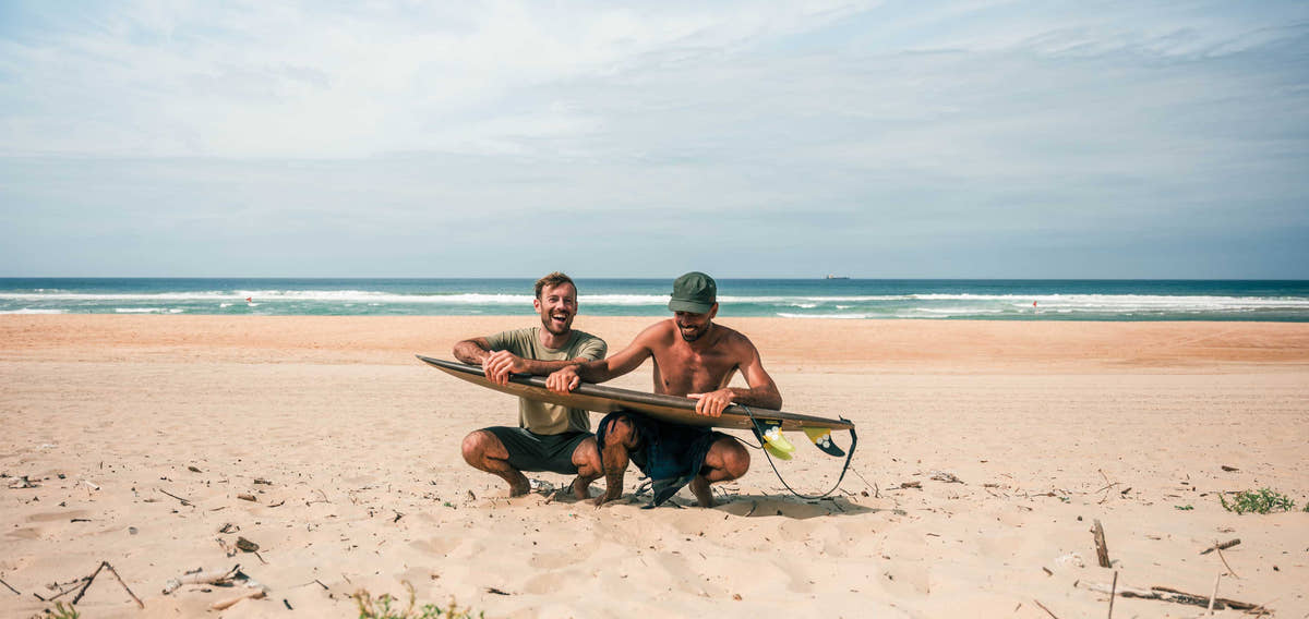 Participants de la retraite de surf Waved sur la plage avec leurs planches