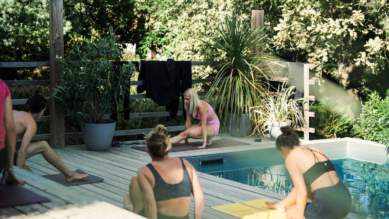 Étirements spécifiques surf au bord de la piscine de la villa