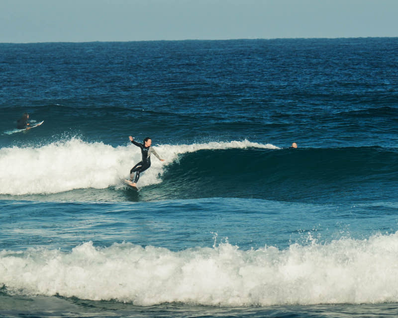 Participante surfant une vague pendant la retraite de surf dans les Landes