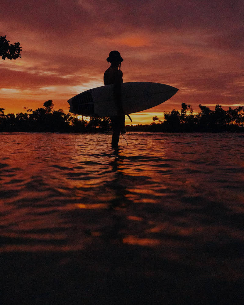 Surfeur avec sa planche au coucher du soleil au Nicaragua