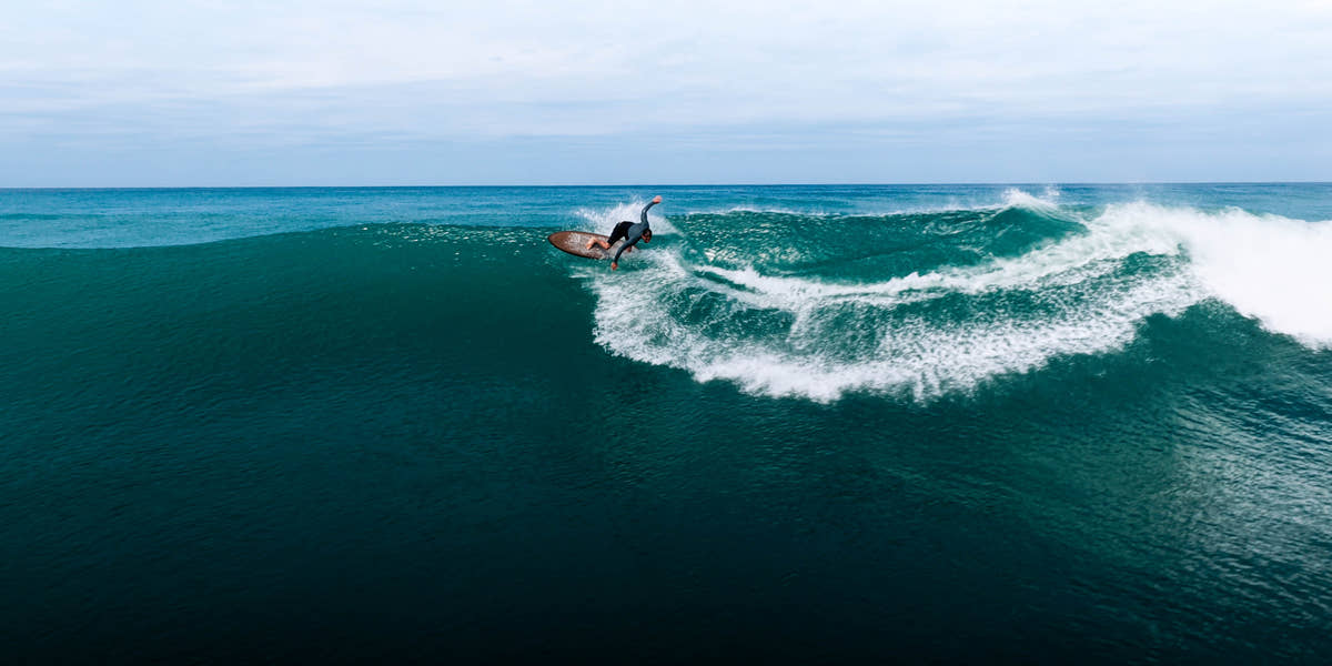 Surfeur sur une vague filmé au drone pendant la retraite de surf